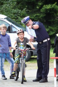 policjant ocenia jazdę rowerzysty na torze przeszkód podczas imprezy Jedź z Głową w Istebnej