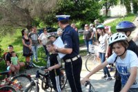Policjant przeprowadza egzamin dla dzieci na kartę rowerową