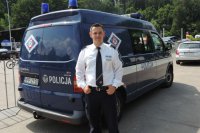 Niemiecki policjant przed policyjnym radiowozem