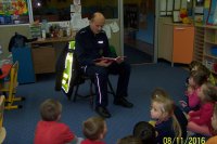 Policjant w przedszkolu czyta dzieciom książkę