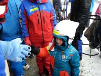 Zdjęcia ze spotkania z dziećmi na lodowisku w Cieszynie- na tafli lodowiska policjant, dzieci oraz pies Sznupek-maskotka śląskiej Policji