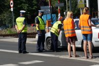 policjanci oraz funkcjonariusze SOK wręczają ulotki kierowcy samochodu