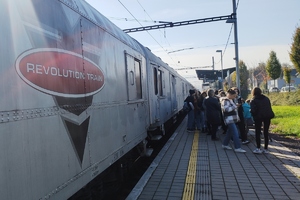 grafika, dzieci stoją na peronie przed pociągiem, na pociągu napis Revolution train