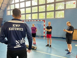 sala gimnastyczna, osoby patrzą na instruktora, który ma napisane na bluzie KWP Katowice